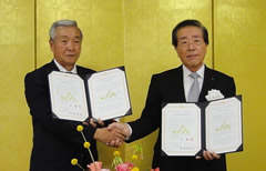 調印書にサインし、握手を交わすＪＡめむろ辻組合長（写真左）とＪＡいび川堀尾組合長
